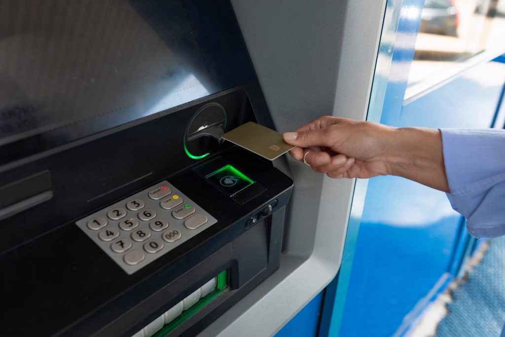 Customer using a reverse ATM to convert cash into a prepaid card at a modern retail venue